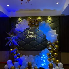 A classic and striking color combination of royal blue, white, and gold. This full ring balloon arch with dramatic uplighting creates a sophisticated and celebratory focal point for any adult party.