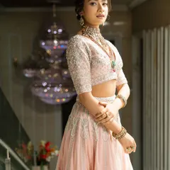 Twirl into a fairytale with this baby pink bridal lehenga. I designed it with intricate horse embroidery on the raw silk skirt and paired it with a heavily handworked blouse and a delicate net dupatta for a truly heavenly look.