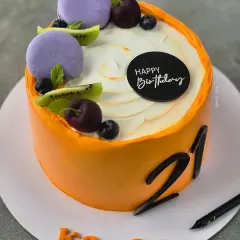 A vibrant orange cake for a 21st birthday. This is my Frutilicious Vanilla flavour, topped with fresh cherries, kiwi, blueberries, and macarons.