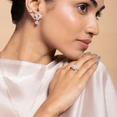 A classic profile shot perfect for showcasing earrings and rings. The clean lighting highlights the sparkle of the diamond-simulant stones without creating harsh reflections. The model's elegant pose and neutral styling keep the focus entirely on the jewelry.