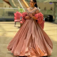 A full-length shot of a bride in a princess gown, her hair in a chic high ponytail. This hairstyle is modern, comfortable, and keeps the focus on the outfit's dramatic sleeves.