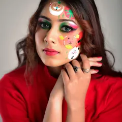A close-up of the Christmas-themed makeup. You can see the details of the hand-painted Santa and snowman on the model's face, combined with a festive green and red eye look.
