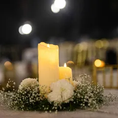 A simple yet elegant centerpiece of candles and baby's breath. Thoughtful details like this on every table contribute to the overall ambiance of the event.