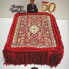 This incredibly detailed carpet-themed cake was made for a carpet expert's 50th birthday. The Persian rug design is an edible print, and the fringe is made from hand-rolled fondant, showcasing my ability to tackle unique themes.