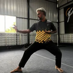 Our Sensei strikes a classic martial arts pose, showing readiness and focus. The foundation of all movement is a strong stance.