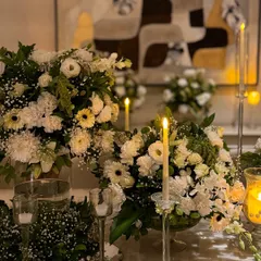 A classic and timeless centerpiece arrangement of white flowers and baby's breath. Paired with elegant crystal candle holders, this creates a sophisticated and romantic ambiance for any event.