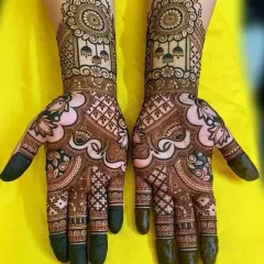This design features traditional jhumka (earring) motifs and mandalas on the back of the hands. The palms are filled with classic checkerboard and paisley patterns, creating a full and festive look.