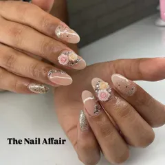 An elegant and glamorous design on almond nails, featuring 3D roses, scattered rhinestones, and a glitter accent nail. A stunning choice for a wedding.