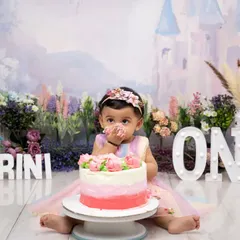 A little taste of frosting to celebrate turning one. This baby girl is enjoying her beautiful pink ombre cake in our whimsical fairytale castle setting, complete with her name in lights.