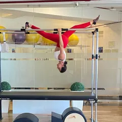 Our founder, Taru, demonstrates an incredible inverted split on the Cadillac, a move that requires exceptional flexibility, strength, and trust in the equipment.