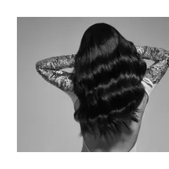 A simple yet glamorous shot focusing on texture and light. The backless top with shimmering sequin sleeves contrasts with the model's dark, flowing hair, creating a beautiful study in monochrome.