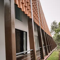 A close-up of the Tellado Villas' facade, showcasing the unique application of red mission tiles on a curved surface. This detail is a testament to our approach of blending heritage-inspired materials with a fresh, contemporary twist.