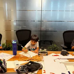 The design phase is just as important as the building. Here, a young roboteer is sketching out ideas for his soccer robot, planning the mechanics and strategy before assembly begins.