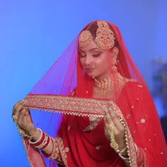 The bride with her veil. The red colour is so vibrant and the makeup is designed to stand out beautifully against it.