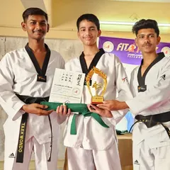 Two of our black belt coaches award a student his new green belt, certificate, and trophy. We recognize and reward the hard work of our students.