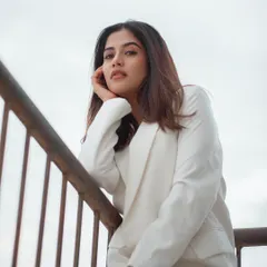 A rooftop portrait with a clean, minimalist feel. The white blazer and the bright, open sky create a high-key look that is both modern and sophisticated.