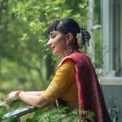 A profile shot enjoying a moment of calm, with the traditional gajra and jewellery complementing the beautiful saree.
