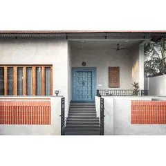 With a modest elevation, we wanted the main door to be an eye-catching feature. We conceptualized a traditional carved teak door but chose to polish it in a gorgeous steel blue that stands out, telling a story of being traditional yet unconventional.