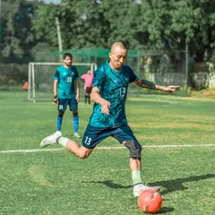 A player strikes the ball with power and precision. Our well-maintained natural grass fields provide the perfect surface for high-quality football.
