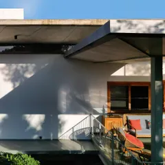 The exterior of the 'House of Canopies', where cascading, cantilevered concrete roofs provide shelter and create a distinctive, modern silhouette.