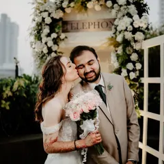 A sweet moment captured at the floral-draped telephone booth.