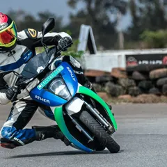 A rider testing an Ather scooter, getting a knee down to test its handling and performance capabilities.