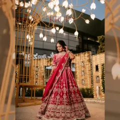 A magnificent full-length portrait of the bride in her stunning red reception lehenga. The festive lights and grand archway create a magical backdrop, making her look truly regal.