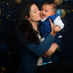 A mother's love captured in a sweet kiss. This was taken against a festive balloon backdrop in my studio, perfect for celebrating a milestone.
