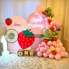 Another view of the strawberry first birthday, showing the light-up number '1' and personalized backdrop.
