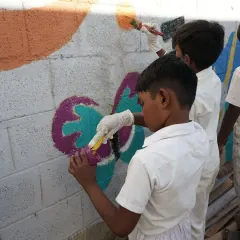 A young artist carefully painting a butterfly. During these community wall art projects, I see so much focus and passion in the kids. It reminds me that creativity is a natural instinct, and all they need is the space and freedom to express it.