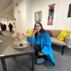 Me with one of my ceramic bust sculptures at a gallery show. This piece features an illustrated surface and a surreal, cloud-like hair form.