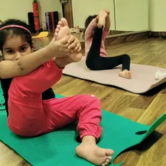 It is a joy to watch these little yogis explore their flexibility and strength. This young student is practicing a variation of a seated leg cradle, which is wonderful for opening the hips.