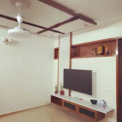 This television unit is an example of my "less is more" philosophy. The floating console keeps the floor clear, making the room feel larger, while the wood-paneled shelving and ceiling detail add architectural interest without clutter.