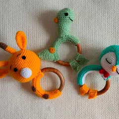 These are some of my new rattle toy designs. I have a giraffe, a dinosaur, and a sleeping penguin, all with a safe wooden ring for babies to hold. They make a little sound and are a very pretty gift for a newborn.
