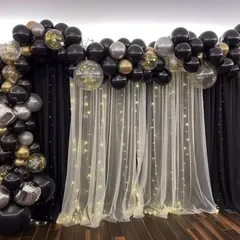 I can create a sophisticated and versatile backdrop for any occasion. This design combines a black and silver balloon arch with a sheer white curtain and fairy lights, offering a classic and elegant setting for photos at parties and events.