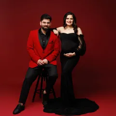 A bold and passionate maternity portrait. The couple's coordinated red and black formal wear makes a striking statement of their connection and excitement.