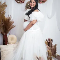 A beautiful maternity photoshoot makeover. The all-white theme with the flowing gown creates an angelic and serene look for the mom-to-be.
