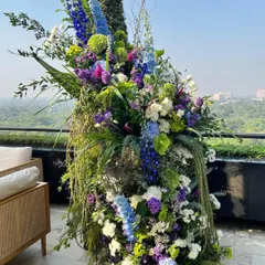This outdoor installation is what I call beautiful chaos. I combined lush greens, vibrant purples, and dreamy blues to create a floral odyssey that feels wild and untamed, yet perfectly composed. It’s about going bold and letting the flowers tell their own story.