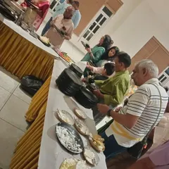 Guests lining up at the buffet during a housewarming and anniversary celebration. We ensure the food flow is smooth and organized, even at busy events.