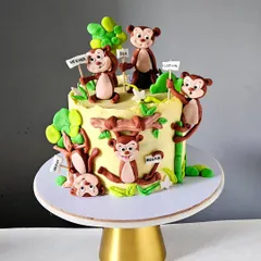 A playful "Five Little Monkeys" cake, where each monkey represents a child in the family. I gave each hand-sculpted monkey a unique, mischievous expression, and they are all playing in a colorful jungle scene.