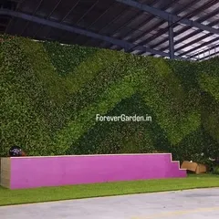 For events and commercial spaces, I create large-scale backdrops. This is a massive vertical garden wall with a geometric two-tone green pattern, installed as a stage background in a warehouse.