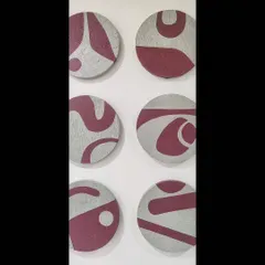 A direct, close-up view of six of the textured circular panels. You can see the raised texture of the base and the smooth, contrasting maroon shapes that form a continuous abstract design.