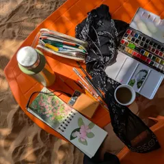 A glimpse of my painting setup during a trip to Gokarna. My sketchbook, watercolor palette, and a cup of tea are all I need to create on the go.