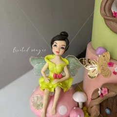 A close-up of the fairy topper from a first birthday cake. Her delicate, transparent wings are completely edible, adding a touch of magic.