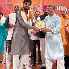 Receiving the award on stage at the Taal Sargam Academy event.