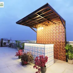 The custom-built bar at our Palam Vihar project, with a vibrant tiled front and a terracotta jaali screen backdrop.