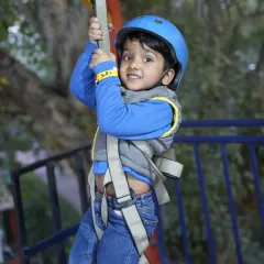 A close-up of one of our youngest adventurers, confidently holding on as he enjoys the zipline ride. Our team ensures even the little ones feel secure.
