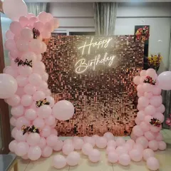 A beautiful rose gold sequin wall framed by a soft pink balloon arrangement, creating a chic and modern photo spot.