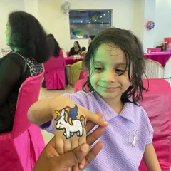 A happy guest showing off her brand new unicorn tattoo. My temporary tattoo artists are skilled at creating fun, colorful, and kid-safe designs that are a favorite at any party.