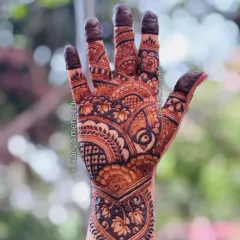 A full-hand design for a sider, featuring a mix of traditional Indian motifs like lotuses and paisleys, with filled-in fingertips for a classic look.